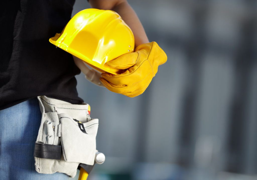 Gelber Helm und Arbeitshandschuhe