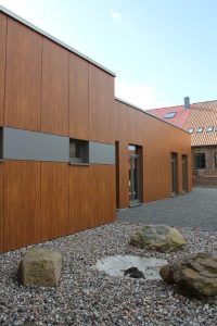Holzfassade mit Steinen im Hof